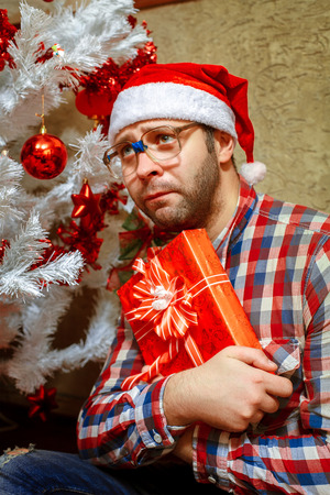 sad lonely nerd with christmas gift.の写真素材