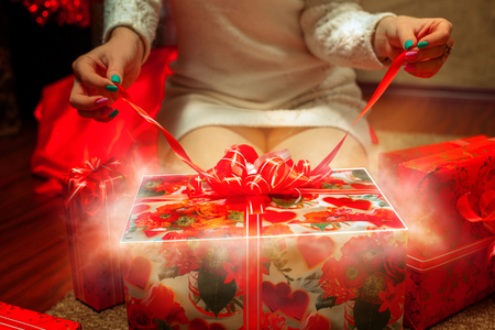 Girl unpacks a glowing magic giftの写真素材