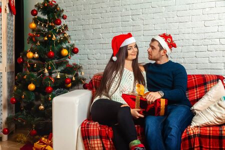 Lovely happy couple on couch with christmas gifts. New year. CHristmas mood.の写真素材