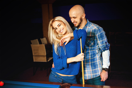 Fashionable couple having fun and plays billiard.の写真素材