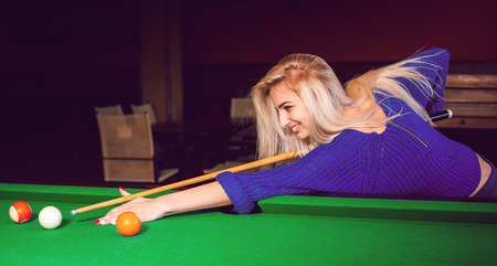 panoramic photo lovely blonde girl playing on the pool table.