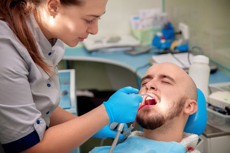 beautiful boy treats his teeth in a dental office by the doctor.の写真素材