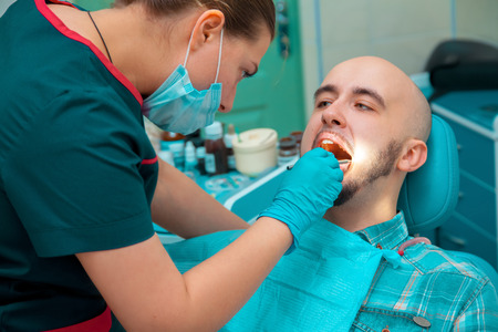 man taking care of his health checks teeth at the dentist.の写真素材
