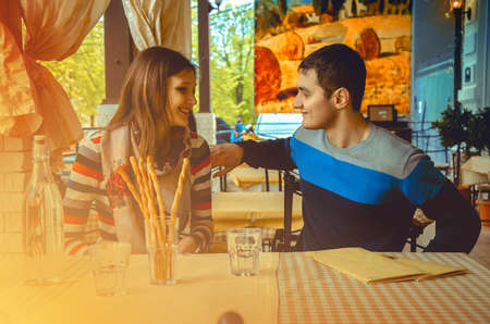 guy flirting with his girlfriend on a date in an outdoor cafeの写真素材