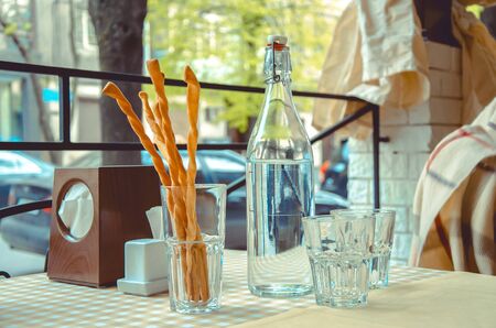 bottle of water and breadsticks on the table in an Italian restaurantの写真素材
