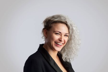 beautiful girl laughing in the studio on a gray backgroundの写真素材