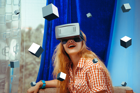 horizontal portrait of surprised woman in virtual reality glasses with 3d cubes around. VR helmet. third dimension. Virtual reality glasses.の写真素材