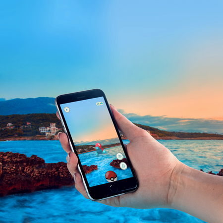 Bar, Montenegro - 9 July 2014: Black Apple iPhone 6s held in one hand showing its screen with Pokemon Go applicationのeditorial素材