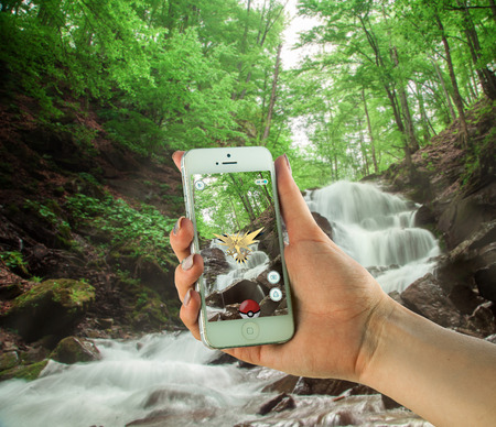 Zakarpattya, Ukraine - 15 May 2016: White Apple iPhone 5s held in one hand showing its screen with Pokemon Go applicationのeditorial素材