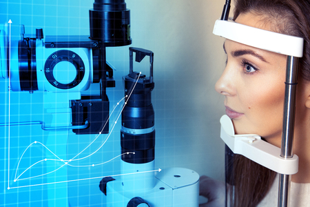 Future medicine and health concept. Ophthalmology. Beautiful woman checks her vision at the future clinic. Virtual sensors for checking vision.の写真素材