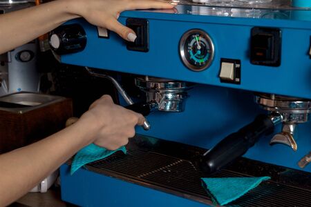girl works with a blue coffee machineの写真素材