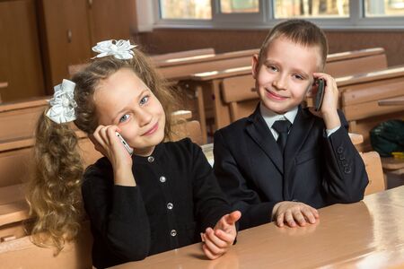 Children are speaking on the telephone at school