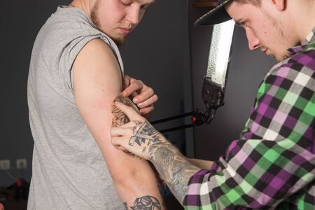 Tatooer is tying a mockup of a rose to the handの写真素材