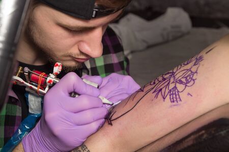 Tatooer working with a tatoo machineの写真素材