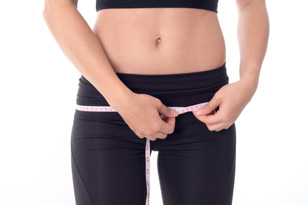 close-up of a beautiful body and abdomen of a young girl which measures the volume of the thighsの写真素材