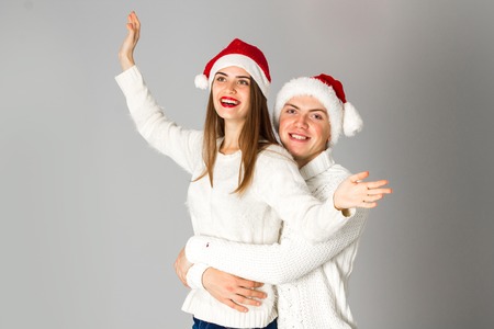 portrait of young beauty couple celebrate christmas in studio on grey backgroundの写真素材