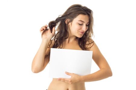 sexy nude brunette girl with placard isolated on white backgroundの写真素材