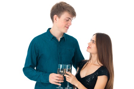 cute young couple in love with two glasses of champagne in studio on white backgroundの写真素材