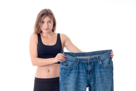 a young girl stands up straight and holding a big wide pantsの写真素材