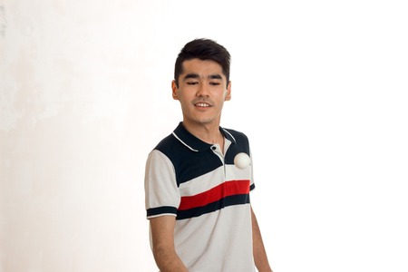 young brunette man playing table tennis isolated on white background in studioの写真素材