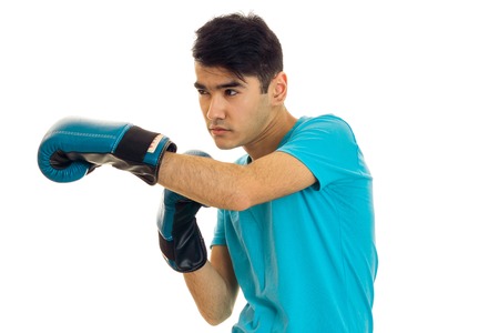 young brunette man in blue boxing gloves practicing isolated on white backgroundの写真素材