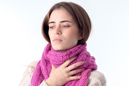 young girl caught a cold and keeps the scarf on the neck close-upの写真素材