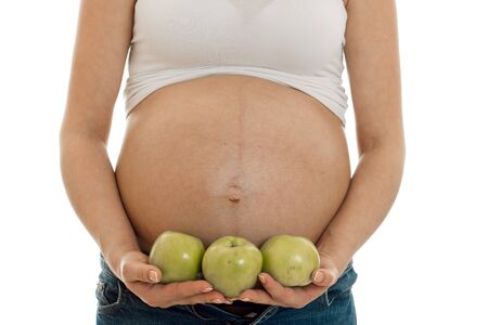 pregnant mother isolated on white in studio posing with green applesの写真素材