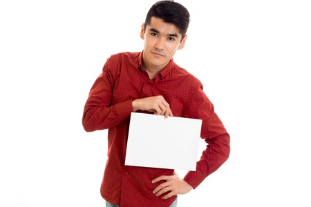 handsome young guy in red shirt with empty placard in hands posing isolated on whiteの写真素材