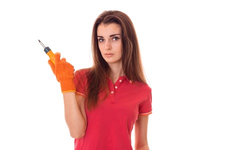 young brunette woman builder makes renovation with screwdriver in her hands isolated on whiteの写真素材