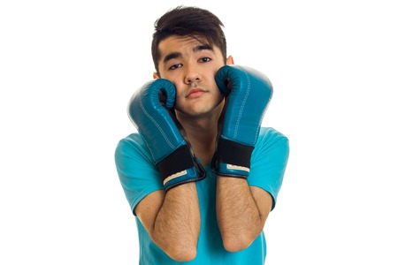 portrait of funny guy practicing boxing in blue gloves isolated on whiteの写真素材