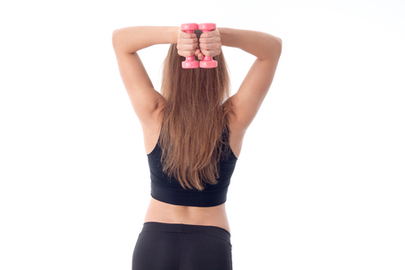 girl holds a sports head over to little dumbbell isolated on white backgroundの写真素材