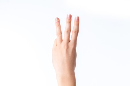 female hand showing three fingers isolated on whiteの写真素材
