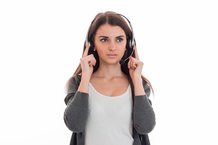young girl in headphones seriously looks toward isolated on white backgroundの写真素材