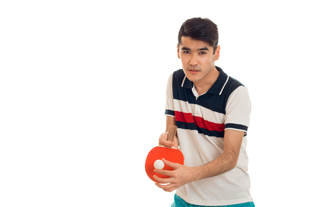 cute young brunette man in uniform practicing table tennis isolated on whiteの写真素材