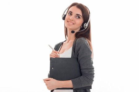 cute young girl with headphones is smiling looks away and keeps the folder in the hands isolated on...
