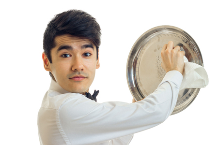 Portrait of a handsome young waiter that looks into the camera and side tray cloth close-up isolated on white backgroundの写真素材