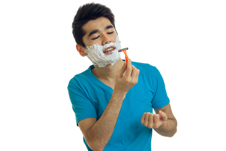 young Brunettes with facial foam shaves using a grinder isolated on white backgroundの写真素材
