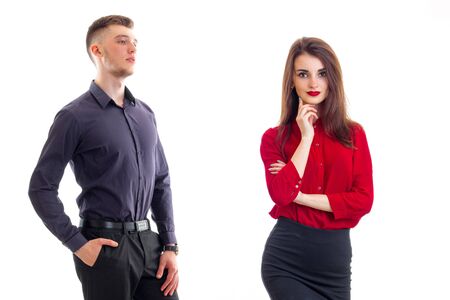 young strong guy in a shirt standing next to the charming girl with red lipstick on lips and red blouse isolated on white backgroundの写真素材