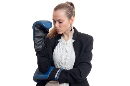 sexy young blonde in a black jacket and shirt stands in boxing gloves hanging its head isolated on white backgroundの写真素材
