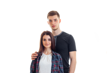 smiling beautiful girl standing next to a young high guy and looking at camera isolated on white backgroundの写真素材