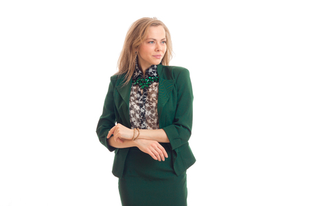 gorgeous young blonde in jacket stands up straight and looks toward isolated on white backgroundの写真素材