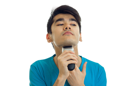 Portrait of a guy in a t-shirt which raised my head up and shaves his beard is isolated on a white background close-upの写真素材