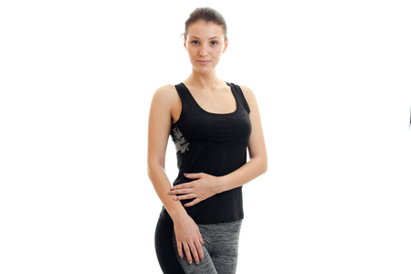 smiling slender girl posing in the Studio in a black t-shirt and trousers is isolated on a white backgroundの写真素材
