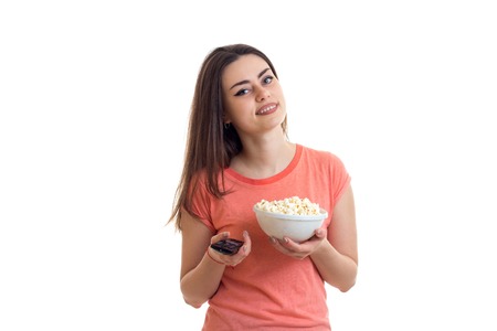 woman with remote control from the tv and popcorn in the hands isolated on white background