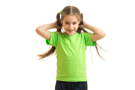 Cheerful little girl in green shirt smiling on holding in hands a horsetail isolated on white backgroundの写真素材