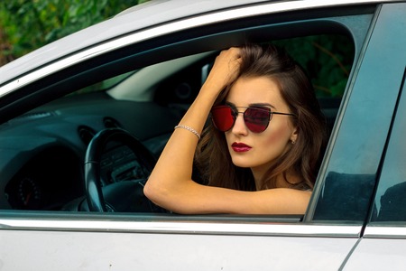 close-up portrait of a chic girls with glasses in the carの写真素材