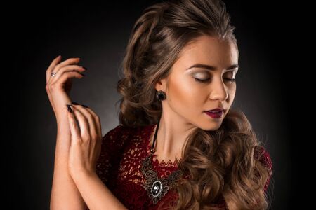 Charming young girl with beautiful curly hairstyle in studio