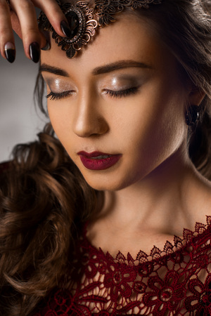 Charming young girl with beautiful curly hairstyle in studioの写真素材