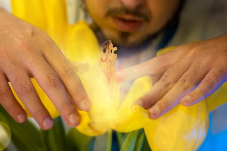 close up of man grew a sexy girl in the yellow blooming flower