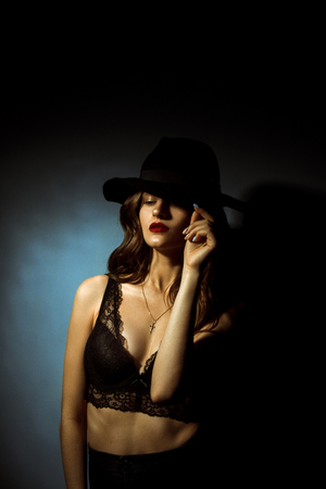 Gorgeous young lady with curly hairstyle in dark studioの写真素材